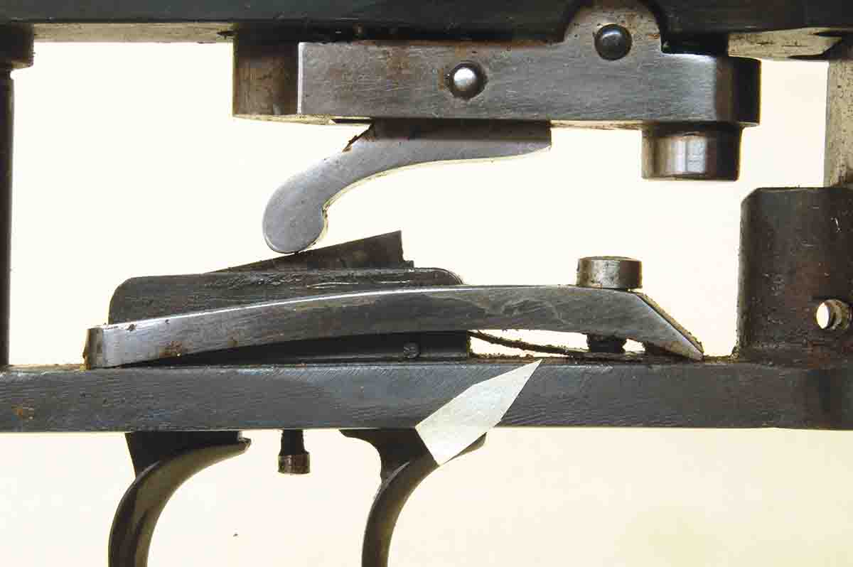 The space under the large flat spring (arrow) allows increasing pressure on the rear trigger.